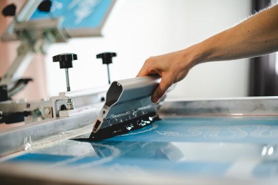 Screen printing ink being pulled across a screen